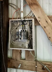 An open electrical panel showing wiring and circuit breakers, indicating an upgrade or repair by Lighten Up Electric, LLC in Cranston, RI.