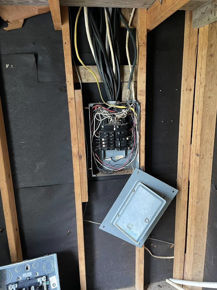 An electrical panel with exposed wiring and the cover removed by Savoski's Electrical & AC, LLC in Sunset, LA