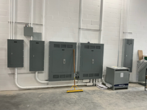 Installed electrical panels and conduits on a wall, showcasing work by CM Armitage Electrical Contracting Inc in Rochester, NY.