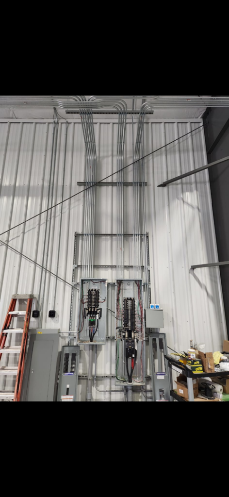 Electrical panels and conduits installed on a wall, showcasing commercial electrical work by Island Electric in Grand Island, NE.