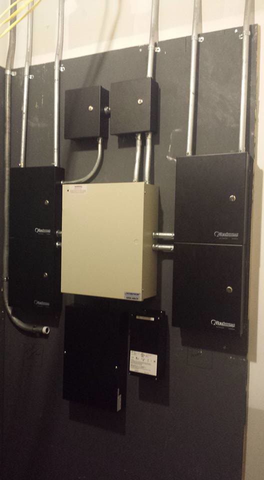 Electrical panels, conduits, and wiring installed on a wall by Triple G Electrical Services in Alabaster, AL