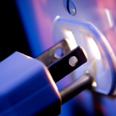 A close-up view of an electrical plug being inserted into a wall outlet, representing services from Your Gilbert Electrician in Gilbert, AZ.