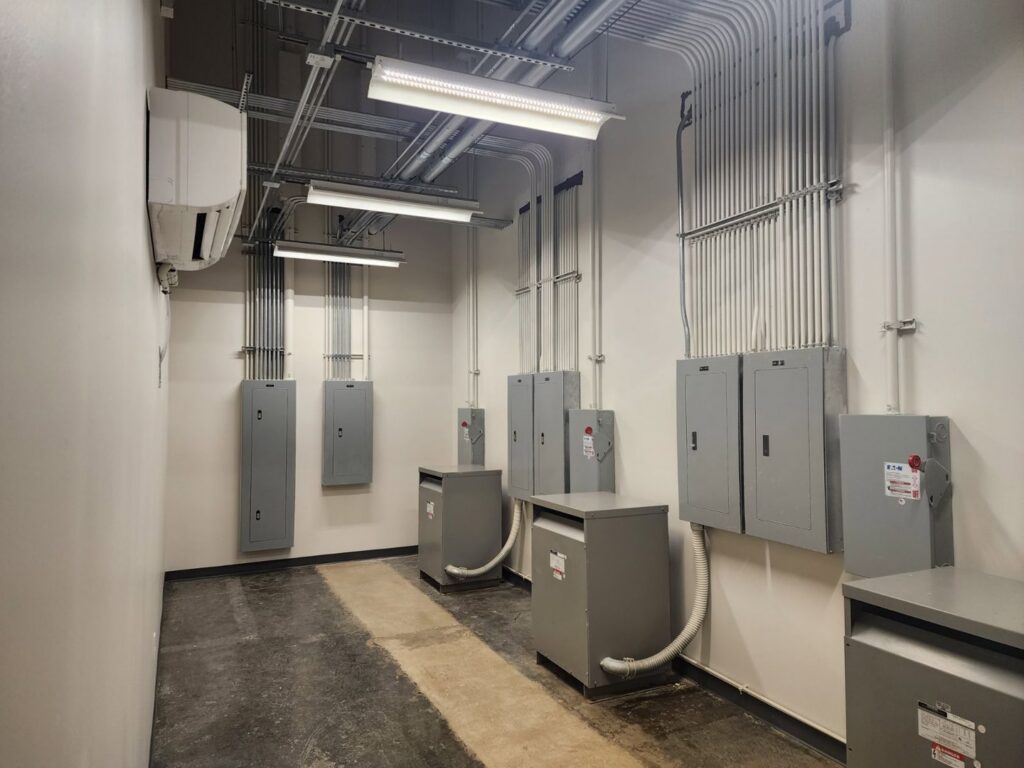 An electrical room featuring multiple service panels and extensive conduit work by Apex Electric LLC in Brea, CA.