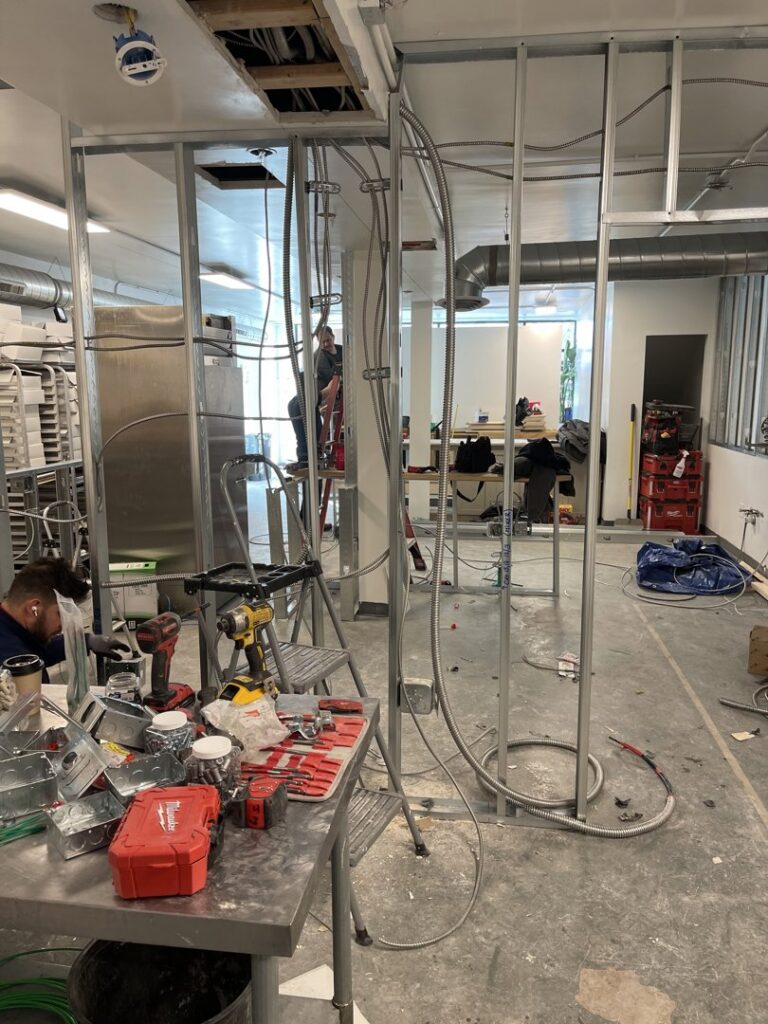 Electrical rough-in work with conduits and boxes being installed in a commercial construction site by Flowers Electric in Aurora, CO.