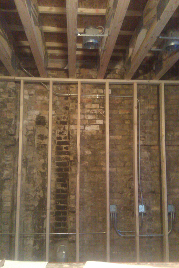 Electrical rough-in work with conduit and junction boxes installed in wall framing by Hunsicker Electrical Services in Chicago, IL.