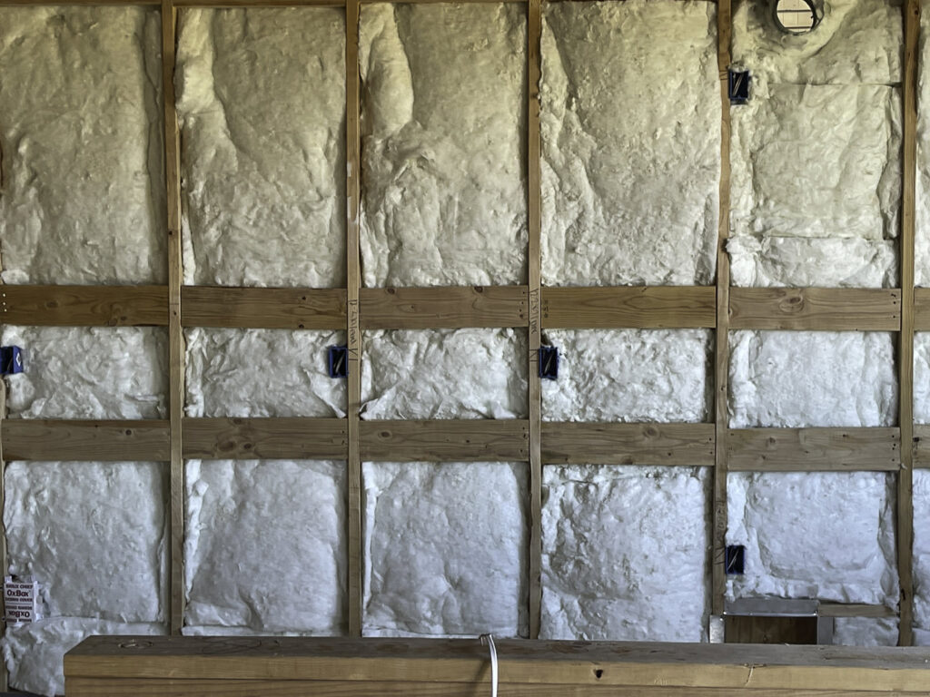 Electrical rough-in with insulation in a wall by Elving Electric in Marysville, WA
