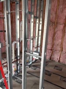 Electrical rough-in with conduits and boxes in metal stud framing during new construction by Tier 1 Electric in Boise, ID.