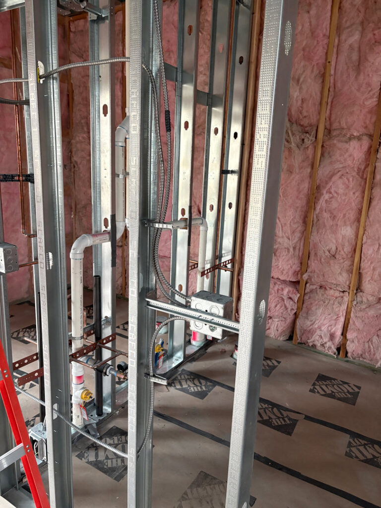 Electrical rough-in with conduits and boxes in metal stud framing during new construction by Tier 1 Electric in Boise, ID.