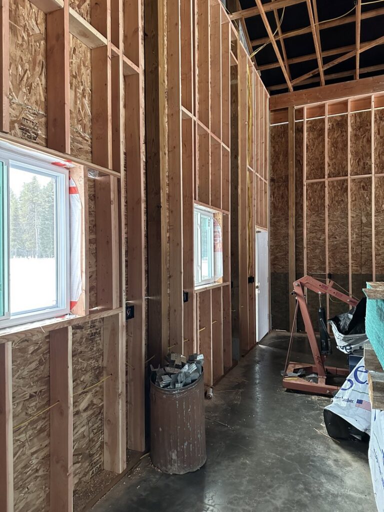 Electrical rough-in with wiring and outlet boxes installed in wall framing during construction by Sunrise Electric LLC in Kalispell, MT.