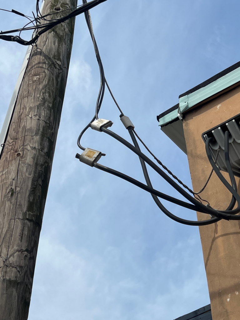 Electrical service wires connecting from a utility pole to a building, installed by Haddad Electric LLC in Jersey City, NJ.