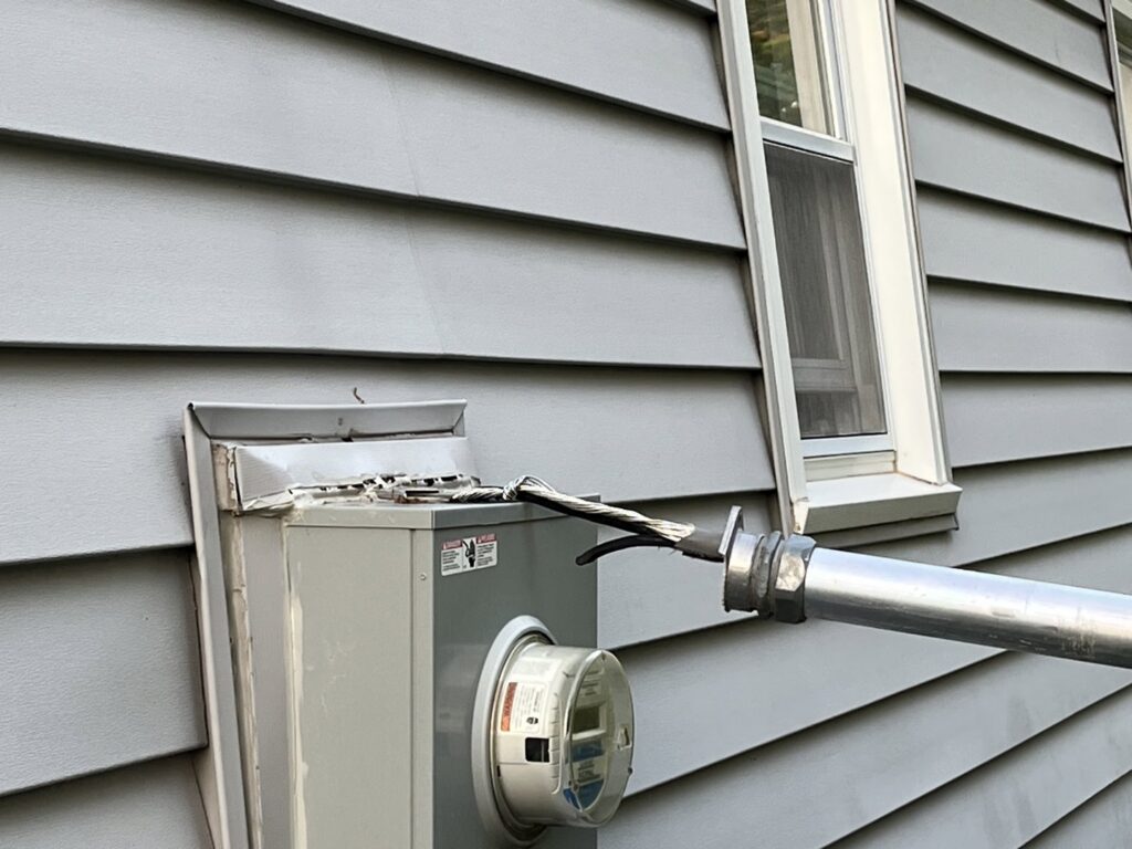 Damaged electrical service entrance wires at a meter box on a house exterior by In the Light Electrical LLC in Kansas City, KS