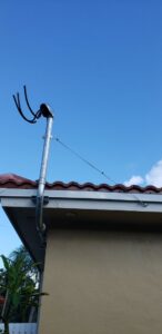 An electrical service mast and conduit installation on a residential roof by Electricians On Call in Fort Lauderdale, FL.