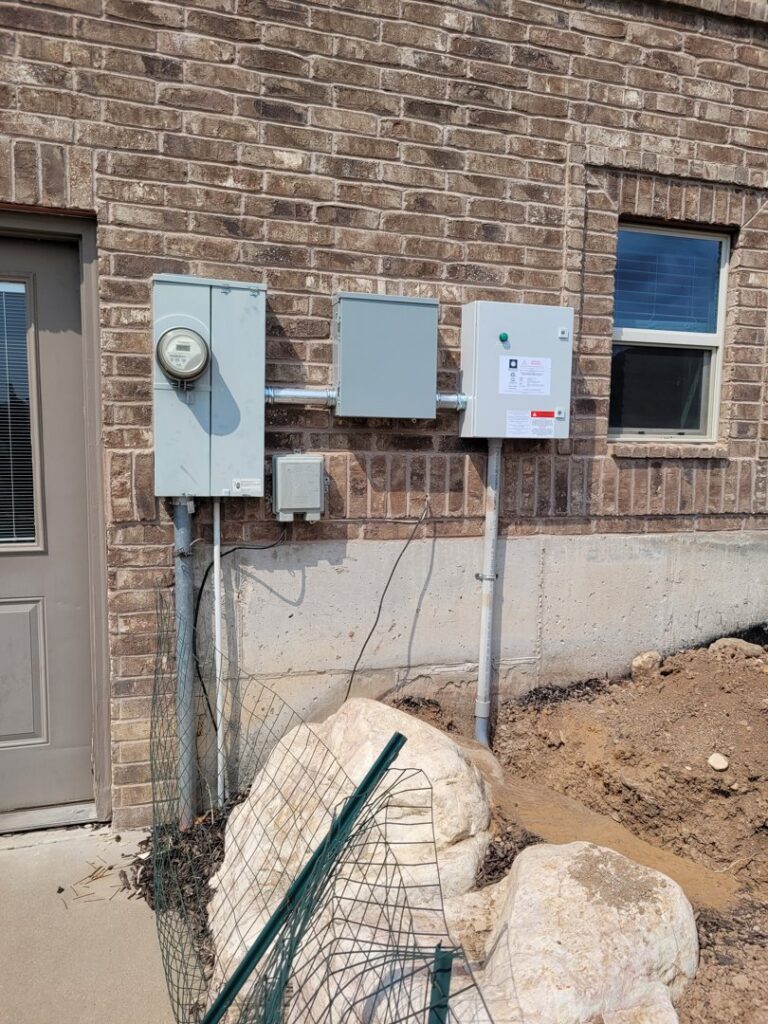 An electrical service upgrade with new meter and panels installed on a brick home by All Aboard Services in Farr West, UT.