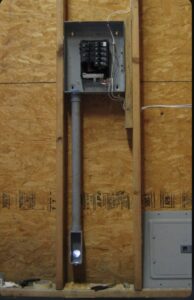 An electrical subpanel installation with conduit on a wooden wall by Electrician Near Me in Broken Arrow, OK.
