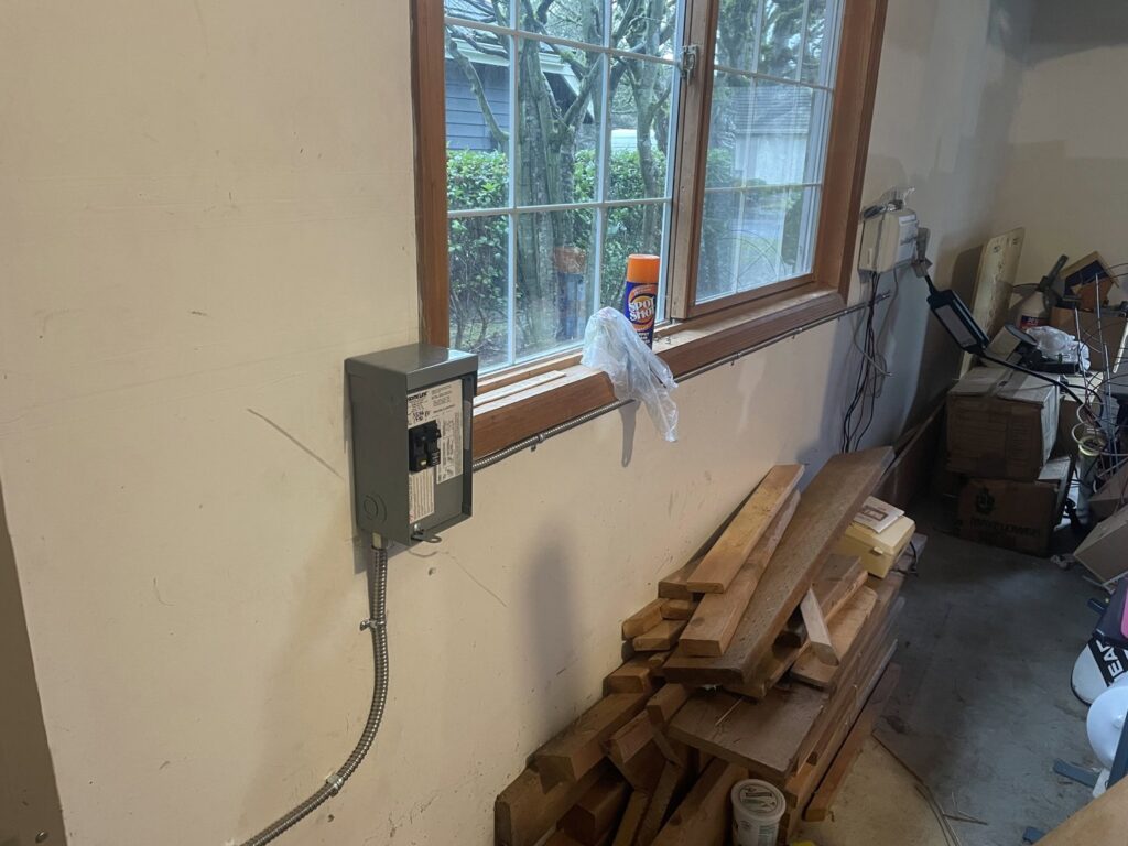 A new electrical subpanel or disconnect box professionally installed in a garage by Alt Electric LLC in Federal Way, WA.