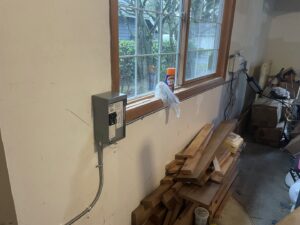 A new electrical subpanel or disconnect box professionally installed in a garage by Alt Electric LLC in Federal Way, WA.