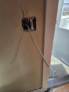 An open electrical switch box with exposed wiring during an installation or repair by DHJ Electric in Methuen, MA.