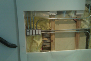 Electrical switch installation with conduit and wiring exposed in a wall by Hunsicker Electrical Services in Chicago, IL.