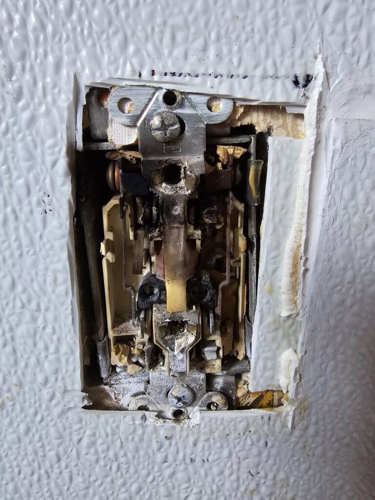 Close-up of a damaged or burnt electrical switch requiring repair by Be Bright Electric in Erie, PA.