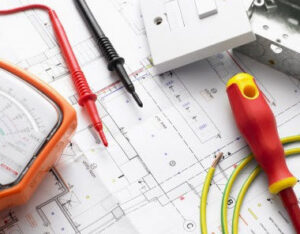 Various electrical tools including a multimeter, screwdriver, wires, and a light switch laid out on blueprints, representing Your Gilbert Electrician in Gilbert, AZ.