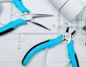 Electrical tools like pliers and cutters laid out on blueprints by Mulholland Electric Inc in San Francisco, CA.