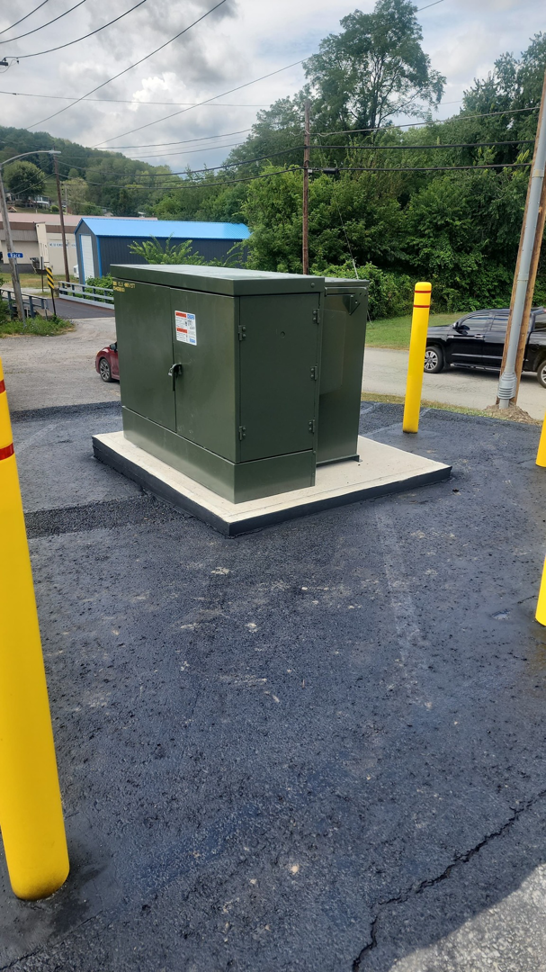 A large green electrical utility box on a concrete pad, installed by Pittsburgh Electric & Maintenance in Pittsburgh, PA