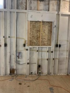 Electrical wiring installation in a framed wall at a job site by Pacific Sun Electric in Oregon City, OR