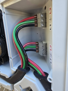 A close-up of electrical wiring installation with red, green, and black wires by Ride the Lightning Electrical Services in El Cajon, CA.