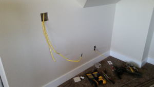 Electrical wiring being installed in a wall with tools on the floor by Northern Lights Electric Company in Sheridan, WY.