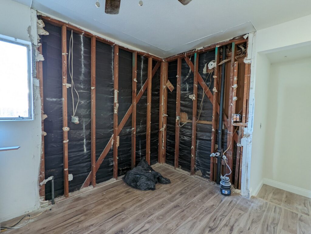 Exposed electrical wiring within wall studs during a renovation, demonstrating rough-in work by Primo's Electrical Services in San Diego, CA.