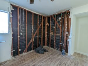 Exposed electrical wiring within wall studs during a renovation, demonstrating rough-in work by Primo's Electrical Services in San Diego, CA.
