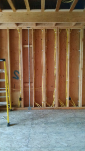 Electrical wiring rough-in in new construction framing by Kavanagh Electric in Fresno, CA.
