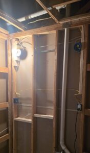 Electrical wiring and junction boxes installed during rough-in with a temporary light by Innovate Electric in Earth City, MO.