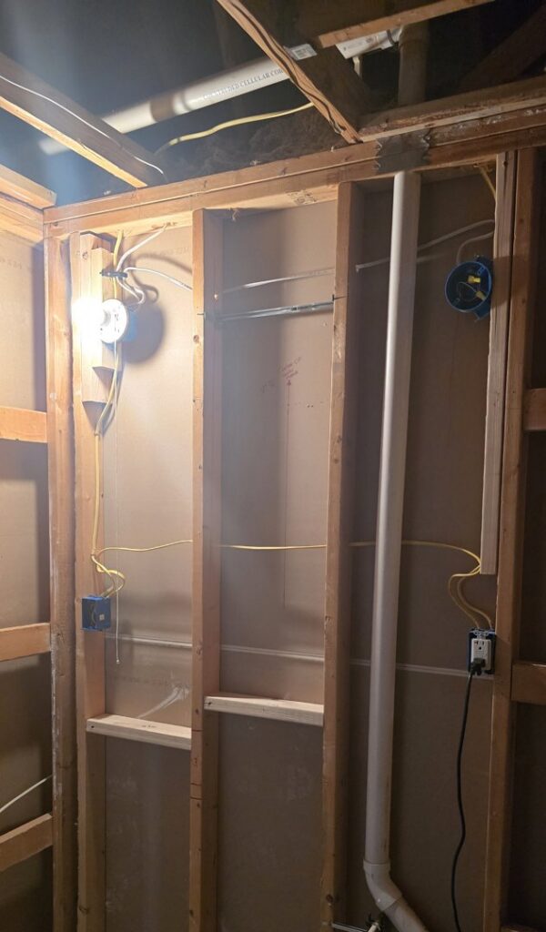 Electrical wiring and junction boxes installed during rough-in with a temporary light by Innovate Electric in Earth City, MO.