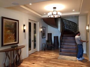 An electrician adjusting a wall sconce in an entryway for President, Cannizzo Electric, Inc. in Rochester, NY.