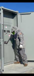 An electrician in arc flash protective gear working on an industrial electrical panel for B&C Electric LLC in Bakersfield, CA