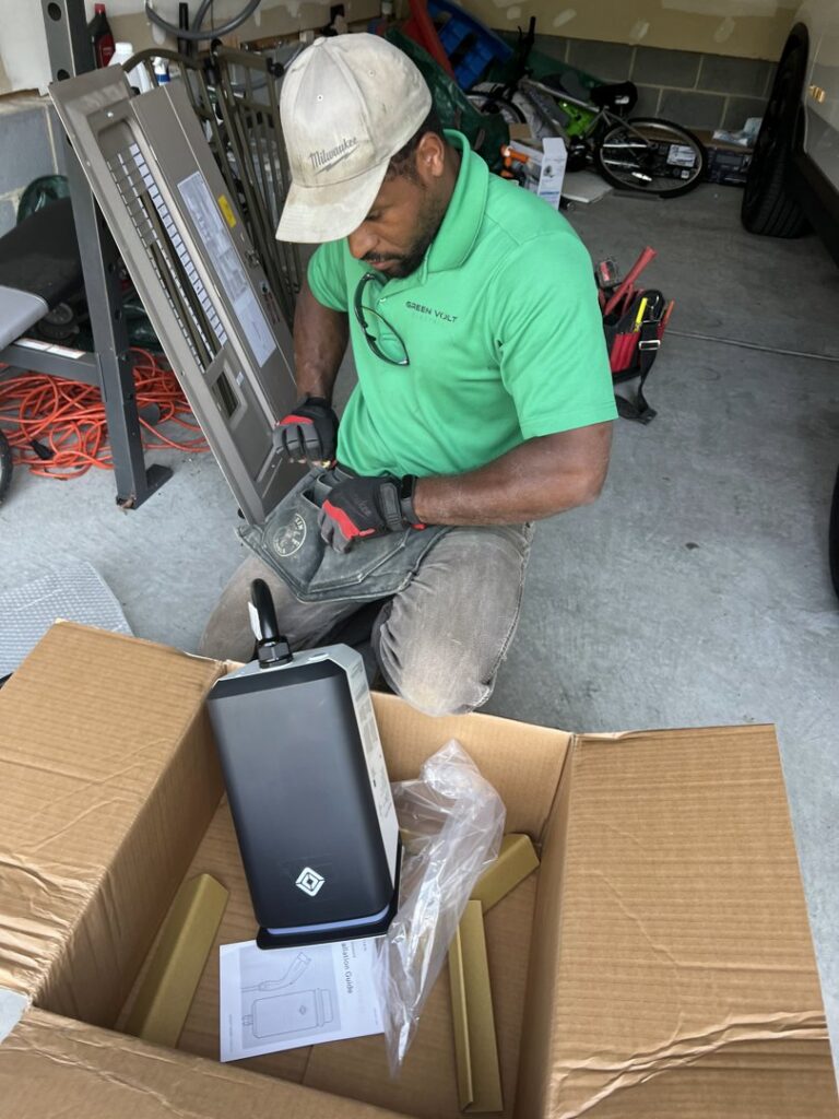 An electrician from Green Volt Electric LLC assembling an EV charging station component in a garage in Durham, NC.