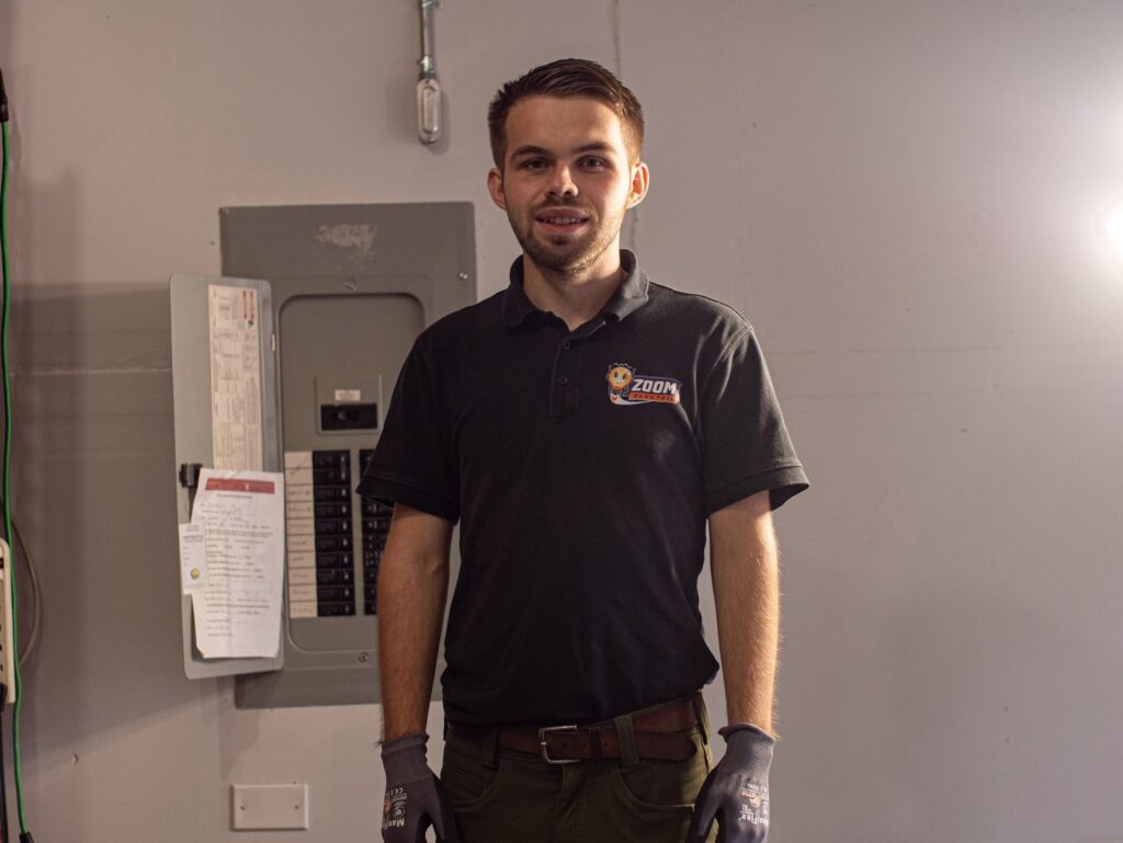 An electrician from Zoom Electric standing in front of an electrical panel in Vancouver, WA.