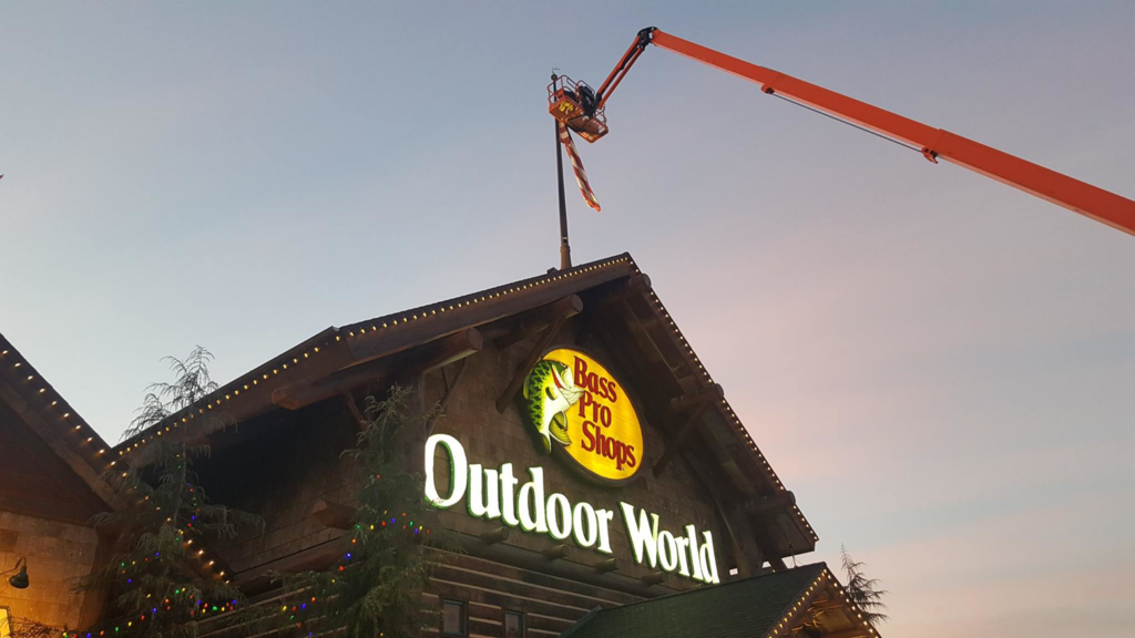 An electrician from High Tech Electric inc. using a boom lift for exterior lighting or sign work in Van Nuys, CA.