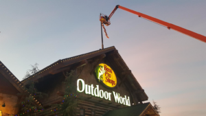 An electrician from High Tech Electric inc. using a boom lift for exterior lighting or sign work in Van Nuys, CA.