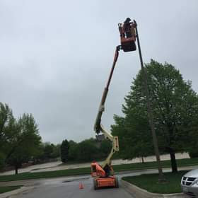 An electrician in a boom lift performing street light repair or installation for Crown Enterprises Electrical Contracting in Omaha, NE.
