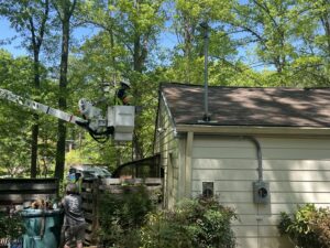 An electrician in a bucket lift working on an overhead electrical service connection to a house for Volt Doctors in Durham, NC