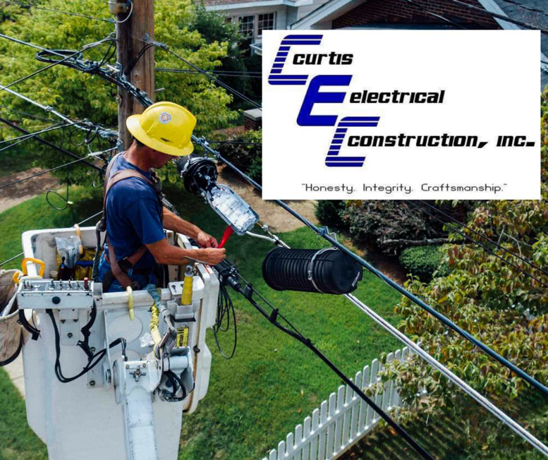 An electrician in a bucket truck performing work on power lines for Curtis Electrical Construction, Inc. in Bakersfield, CA.