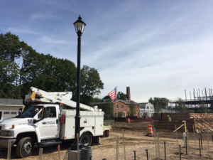 A Pasquariello Electric Corporation bucket truck next to a streetlight pole installation on a construction site in New Haven, CT.