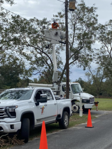 An electrician in a bucket truck performing electrical repair or maintenance on a utility pole for Middle Georgia Electric, Inc. in Macon, GA.