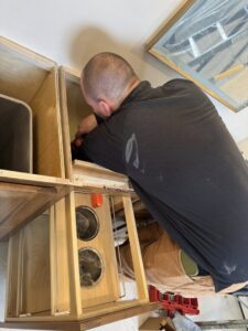 An electrician performing detailed wiring work inside a cabinet for Ace Electrical Services LLC in Owensboro, KY.