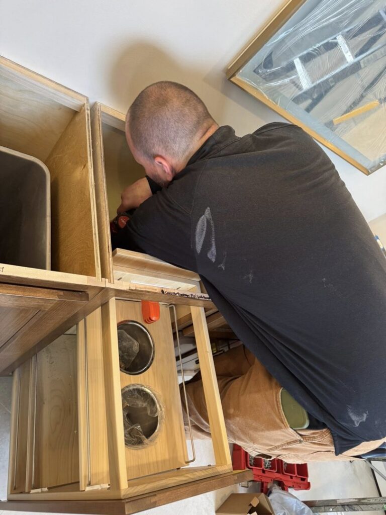 An electrician performing detailed wiring work inside a cabinet for Ace Electrical Services LLC in Owensboro, KY.