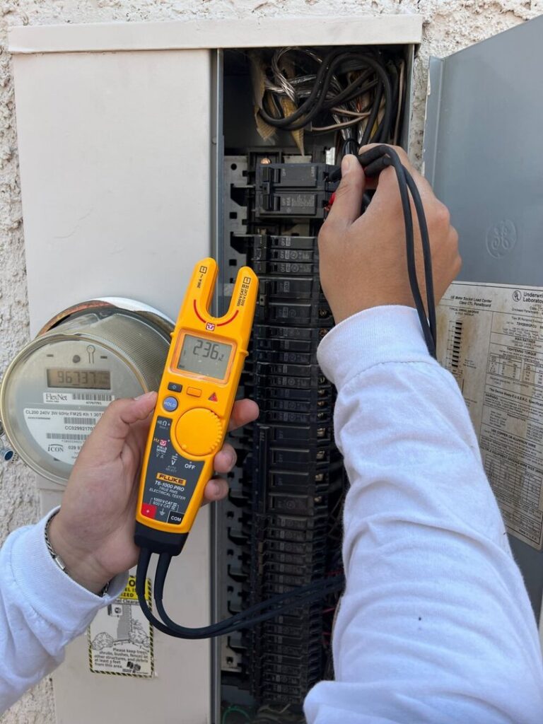An Electricode electrician checking voltage in an electrical panel with a multimeter in Las Vegas, NV.