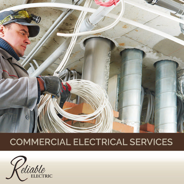 An electrician holding a coil of wire, performing commercial electrical services for Reliable Electric in Olympia, WA.