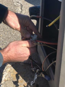 Close-up of an electrician's hands carefully connecting electrical wires during a service call by Rylix Electric in Cincinnati, OH.